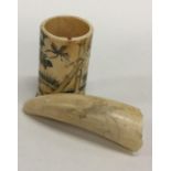 An Antique walrus tooth engraved with a bird toget