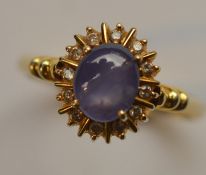 An 18 carat star sapphire and diamond cluster ring