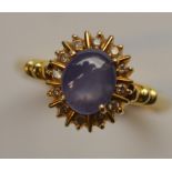 An 18 carat star sapphire and diamond cluster ring