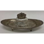 An Edwardian silver inkwell on stand with gadroon
