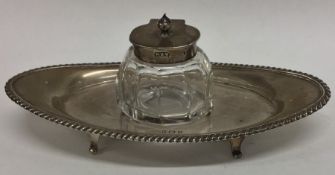 An Edwardian silver inkwell on stand with gadroon