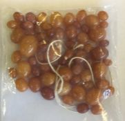 A bag containing numerous amber beads. Approx. 15