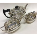 A silver three piece tea service with ebony handle