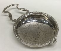 A Georgian silver lemon strainer with pierced bowl