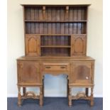 An oak kitchen dresser with plank back and turned