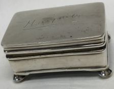 A small rectangular silver jewellery box on ball f