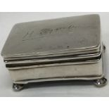 A small rectangular silver jewellery box on ball f