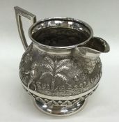 A heavy silver Indian cream jug decorated with fig