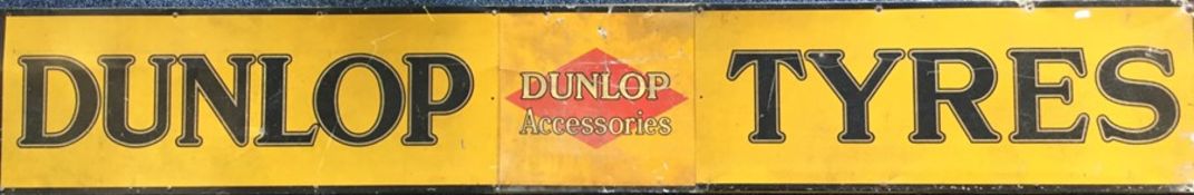 A large rectangular "Dunlop Tyres" metal sign mou