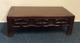 A Chinese hardwood low occasional table with carve