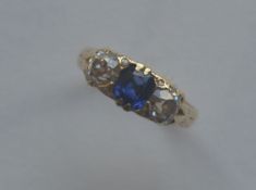 A sapphire and diamond three stone gypsy set ring