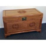 A camphor wood hinged top trunk with brass handle.