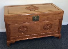 A camphor wood hinged top trunk with brass handle.