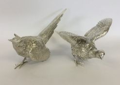 A pair of heavy cast silver models of pheasants wi