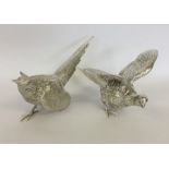 A pair of heavy cast silver models of pheasants wi