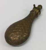 An Antique copper and brass shot flask with weave