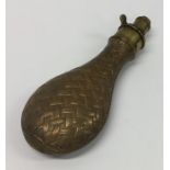 An Antique copper and brass shot flask with weave