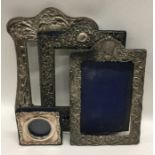A group of three embossed silver picture frames de