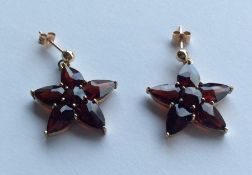 A pair of 9 carat garnet star shaped earrings. App