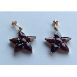 A pair of 9 carat garnet star shaped earrings. App