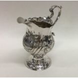 A Georgian silver cream jug embossed with flowers