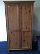 A large pine two door wardrobe on bun feet. Est. £