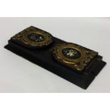 An ebony and pietra dura book slide with brass mou