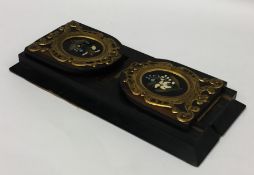 An ebony and pietra dura book slide with brass mou