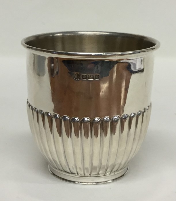 A heavy silver half fluted beaker with gilt interi