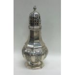 A good cast silver sugar shaker with floral decora