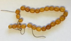 A small graduated string of yellow amber beads. Ap