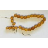 A small graduated string of yellow amber beads. Ap