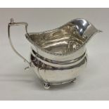 An Edwardian silver cream jug with gadroon rim and