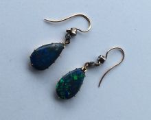 A pair of rare black opal teardrop earrings with r