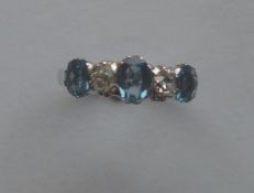 An aquamarine and diamond five stone ring in claw