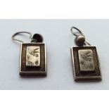 A pair of rectangular silver earrings with loop to