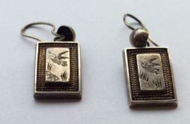 A pair of rectangular silver earrings with loop to