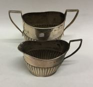 An Edwardian silver half fluted cream and sugar bo