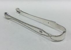 A pair of Georgian silver bright cut sugar tongs.