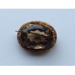 A 9 carat oval topaz brooch embossed with flowers