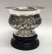 A small embossed silver rose bowl on turned pedest