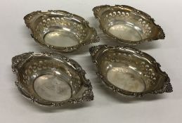 A set of four silver embossed sweet dishes decorat