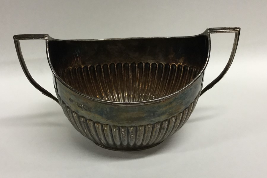 A heavy silver half fluted sugar bowl on pedestal