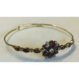 A gold and garnet mounted bangle with large centra