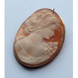An oval cameo of a lady's head in gold frame. Appr