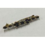 A sapphire and diamond long brooch in claw mount.