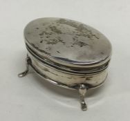 An oval silver hinged top ring box on three spread