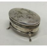 An oval silver hinged top ring box on three spread