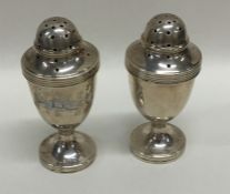 A pair of Edwardian baluster shaped silver peppers