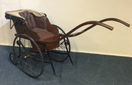 A vintage child's perambulator with spoked wheels